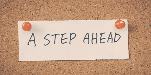 a note that says "a step ahead' is thumbtacked to a bulletin board